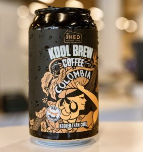 A 330ml can of The Shed Coffee's Kool Brew Coffee Colombia stands on a counter. The design features a stylized woman, which represents The Shed Coffee's promotion and support of the many women who work in all aspects of the coffee industry.