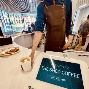 A barista places a to-go specialty coffee with latte art on the counter at The Shed Coffee's location at the Charlottetown Library Learning Centre.